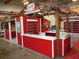 Custom Wood Fabrication Island with Large Fabric and Direct Print Graphics, Storage, Shelving, Seating, and A/V -- Image 1